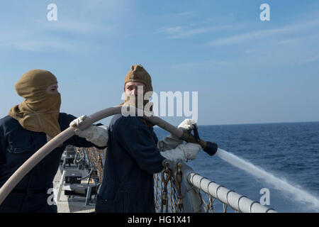 Macchinari Repairman 2a classe Robert Briggs, destra e scafo tecnico di manutenzione marinaio Kirsten Jones uomo un tubo flessibile di scarico durante un controllo del danno esercizio di team a bordo guidato-missile destroyer USS Stout (DDG 55). Stout, home-ported a Norfolk, è su una distribuzione programmata sostenere le operazioni di sicurezza marittima e di teatro la cooperazione in materia di sicurezza gli sforzi negli Stati Uniti Sesta flotta area di responsabilità. (U.S. Foto di Marina di Massa lo specialista di comunicazione 2a classe Amanda R. Gray/RILASCIATO) USS Stout 140107 operazioni-N-UD469-060 Foto Stock