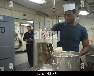 Specialista culinaria di terza classe Brandon Penn dalla U.S. Isole Vergini prepara la cena per i marinai e marines in cucina di trasporto anfibio dock nave USS Denver (LPD 9). Denver è assegnato al Bonhomme Richard anfibio gruppo pronto e sta conducendo le operazioni negli Stati Uniti 7 Flotta Area di operazioni. (U.S. Foto di Marina di Massa lo specialista di comunicazione di terza classe Bradley J. Gee/RILASCIATO) USS Denver attività galley 140302-N-IC565-025 Foto Stock