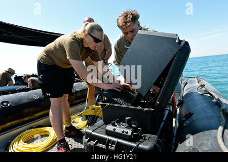 Di Boatswain Mate 2a classe Jennifer Kwiatkowski, sinistra, Chief Boatswain compagno del Ciad Leorin, sia assegnato al comandante del Task Group 56.1, e Mark Fleming, VideoRay un rappresentante tecnico, operare una SeeByte, un Unmanned Underwater veicolo come parte di una evoluzione di familiarizzazione, Marzo 18. CTG-56.1 conduce contromisure mine, l'eliminazione degli ordigni esplosivi, recupero-diving e forza le operazioni di protezione in tutti gli Stati Uniti Quinta Flotta area di responsabilità. (U.S. Foto di Marina di Massa lo specialista di comunicazione 2a classe Taylor M. Smith/RILASCIATO) UUV OPS 140318-N-TM257-018 Foto Stock