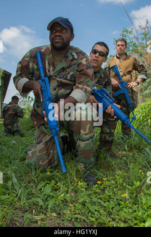 140610-N-IP743-385 LADYVILLE Belize (10 giugno 2014) - Tenente j.g. Jiancarlo Alpuche e sottufficiali di terza classe Raheem Castillo, del Belize Coast Guard guarnizioni, dimostrare come essi si muovono attraverso un campo aperto come Navy l'eliminazione degli ordigni esplosivi tecnico 2a classe Daniel Bracken, dell'eliminazione degli ordigni esplosivi unità mobile (EODMU) 3, osserva. EODMU 3 sta lavorando con il Belize Costa guarnizioni di protezione come parte del sud della stazione di partenariato 2014. A sud della stazione di partenariato 2014 è un U.S. Distribuzione di marina incentrato su un esperto in materia di scambi con i partner nazione le forze armate e le forze di sicurezza Foto Stock