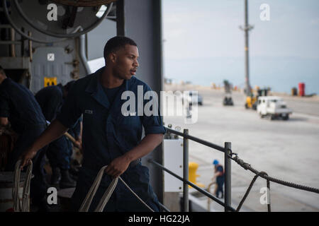 Boatswain compagno del marinaio Jerrick Jeter, da Long Beach, California, lancia una linea di ansante dal dock anfibio sbarco nave USS Germantown (LSD 42) come la nave tira in spiaggia bianca, Okinawa. Germantown è parte di Peleliu anfibio gruppo pronto (#PELARG14), comandato da Capt. Heidi Agle, e sta conducendo le forze congiunte di esercizi in U.S. 7 flotta area di responsabilità. (U.S. Foto di Marina di Massa lo specialista di comunicazione 2a classe Raul Moreno Jr./RILASCIATO) USS Germantown operazioni 141025-N-LP801-011 Foto Stock