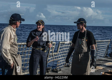 La Cmdr. Linda Seymour, comandante della Arleigh Burke-class guidato-missile destroyer USS Halsey (DDG 97), parla con cuochi dalla valle membri Jeff Peters, sinistra e Mike George, destra durante un acciaio barbecue sulla spiaggia. Cuochi di La Valle è un gruppo eterogeneo di uomini e donne d'affari che, dal 2001, hanno consegnato circa 53 tonnellate di Harris Ranch, 12 once New York bistecche a più di 140.000 i marinai e marines in tutto il mondo. Halsey è sulla distribuzione negli Stati Uniti 7 flotta area di operazioni il supporto di sicurezza e stabilità nella Indo-Asia-regione del Pacifico. (U.S. Foto di Marina b Foto Stock