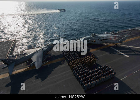 150328-N-LM312-001 ACQUE AD EST DELLA PENISOLA COREANA (28 marzo 2015) - avanti-distribuito Amphibious Assault nave USS Bonhomme Richard's (LHD 6) Dipartimento di alimentazione si sono riuniti per una foto di gruppo sul ponte di volo nella forma di un "E" in onore di essere presentato con il loro xiv consecutivi di gestione logistica Excellence Award, il blu "E". Il Blu "E" viene conferito annualmente a una nave del Dipartimento di alimentazione che soddisfa e/o supera i severi standard elevati impostato da COMNAVSURFOR. Il reparto di approvvigionamento alimentare della divisione di servizio è stato anche premiato per la conquista del 2015 il capitano Edward F. Ney M Foto Stock