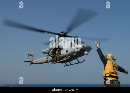 150330-N-NP779-015 ACQUE AD EST DELLA PENISOLA COREANA (30 marzo 2015) - Aviazione di Boatswain Mate manipolazione Airman Newton Armstrong, da Carson, California, un segnalatore di atterraggio arruolato, segnali di un elicottero in partenza dal ponte di volo dell'distribuita Amphibious Assault nave USS Bonhomme Richard (LHD 6). Stati Uniti Marinai e Marines dal Bonhomme Richard anfibio gruppo pronto (ARG) e 31 Marine Expeditionary Unit (MEU) partecipano al Marina Coreana Exchange Program (KMEP) nella Repubblica di Corea (ROK) con il Rok Marine Corps e della Marina. Il Bonhomme Richard Foto Stock