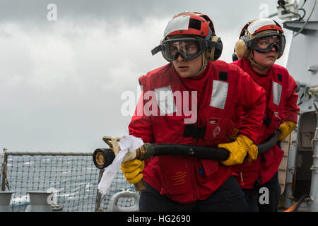 150408-N-ZZ786-217 acque del sud del Giappone (8 aprile 2015) Fire Controlman 3rd Class Thomas Bill, da Levittown, Penn., assegnato all'Arleigh Burke-class guidato-missili cruiser USS Mustin (DDG 89), combatte contro un incendio simulato durante un elicottero atterraggio di emergenza trapano. Mustin è di pattuglia nel 7 ° Flotta area di operazioni a sostegno della sicurezza e della stabilità in Indo-Asia-regione del Pacifico. (U.S. Foto di Marina di Massa Specialista comunicazione David Flewellyn/RILASCIATO) USS Mustin 150408 operazioni-N-ZZ786-217 Foto Stock