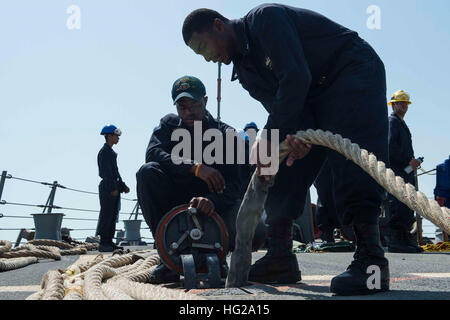 151002-N-VC236-024, Manama Bahrain (2 ottobre 2015) - Cryptologic tecnico (tecnico) 2a classe Arsenio Julien, da Charlotte Amalie, U.S. Isole Vergini, e specialista di operazioni di terza classe Dwight Snowden, da Chicago, stow linee di ormeggio come guidato-missile destroyer USS Farragut (DDG 99) si diparte, Manama Bahrain. Farragut è distribuito negli Stati Uniti Quinta Flotta area di operazioni come parte di Theodore Roosevelt Carrier Strike gruppo supporto di funzionamento inerenti risolvere, colpire le operazioni in Iraq e Siria come diretto, le operazioni di sicurezza marittima e di teatro la cooperazione in materia di sicurezza gli sforzi in t Foto Stock