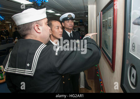 151218-N-RU971-501 Sasebo, Giappone (dec. n. 18, 2015) - comunicazione di massa Specialist 1a classe Ty Connors, distribuita Amphibious Assault nave USS Bonhomme Richard (LHD 6) Public Affairs Officer (arruolato), spiega Bonhomme Richard storia in Giappone marittimo Forza di Autodifesa (JMSDF) Capo Hirosahi Nishitani, anteriore, e Chief Petty Officer Ryuichi Rokutanzono, di Shirane-class destroyer JDS Kurama (DDH 144), nel quadrato di poppa a bordo Bonhomme Richard. Bonhomme Richard è la nave di piombo del Bonhomme Richard anfibio gruppo pronto e viene distribuita a Sasebo, Giappone, negli Stati Uniti 7 Flotta Foto Stock