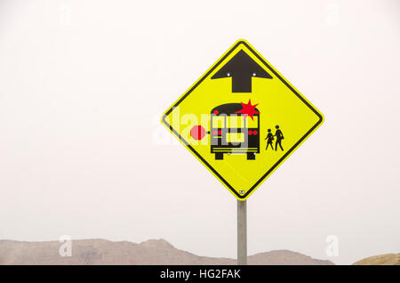 Colorati luminosamente segno per segnalare la presenza di una scuola fermata bus davanti Foto Stock