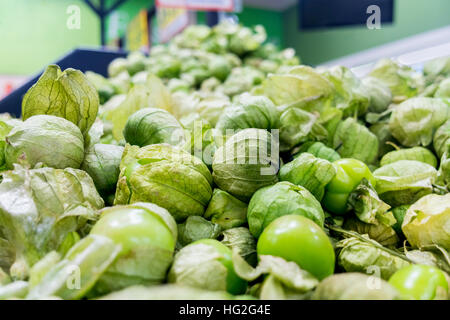 Pila di sfondo di fresco verde biologico tomatillos con bucce. Foto Stock