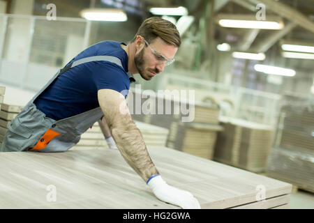 Bel giovane uomo che lavora nella fabbrica di mobili Foto Stock