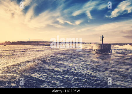 Retrò stilizzata del tramonto su Porto entrata, Ustka, Polonia. Foto Stock