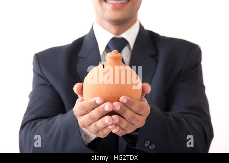 Close-up di giovani professionisti uomo con risparmio di argilla pot in entrambe le mani contro uno sfondo bianco Foto Stock