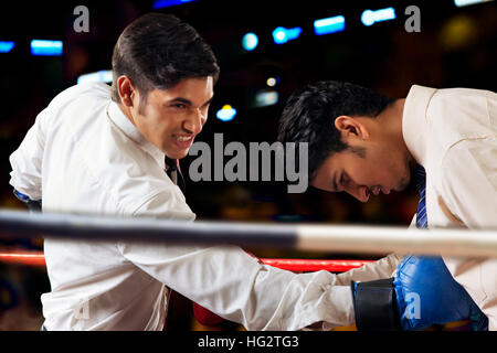 Imprenditori combattimenti nel pugilato ring Foto Stock