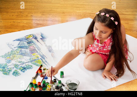 Ragazza seduta sul pavimento e pittura con acquarelli Foto Stock