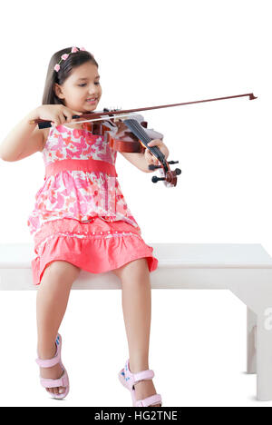 Giovane ragazza seduta sul tavolo a suonare la chitarra Foto Stock