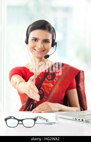 Indian imprenditrice che indossa la cuffia e sorridente Foto Stock