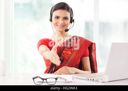 Indian imprenditrice che indossa la cuffia e sorridente Foto Stock