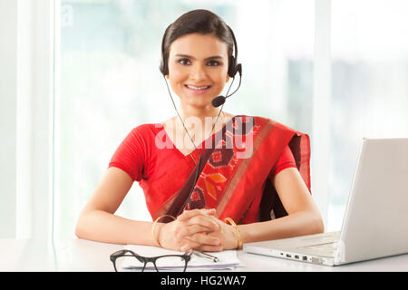 Indian imprenditrice che indossa la cuffia e sorridente Foto Stock