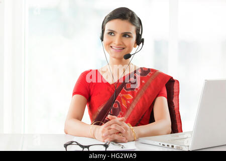 Indian imprenditrice che indossa la cuffia e sorridente Foto Stock