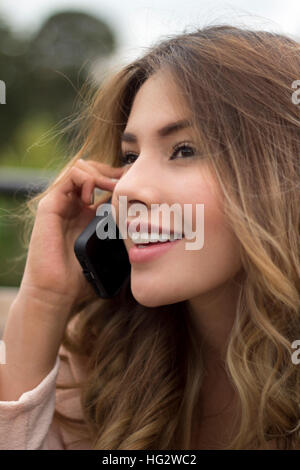 Donna che parla tramite telefono cellulare Foto Stock