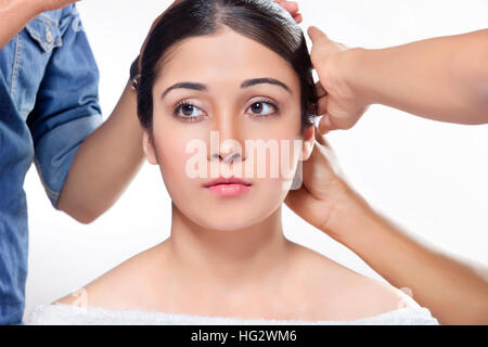 Giovane donna di ottenere capelli stile al parrucchiere Foto Stock