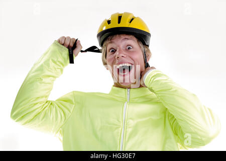 Giovane uomo che indossa giallo bicicletta casco Foto Stock