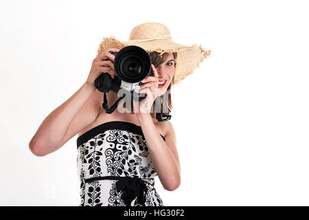 Giovane donna che indossa un cappello per il sole in possesso di una fotocamera digitale Foto Stock