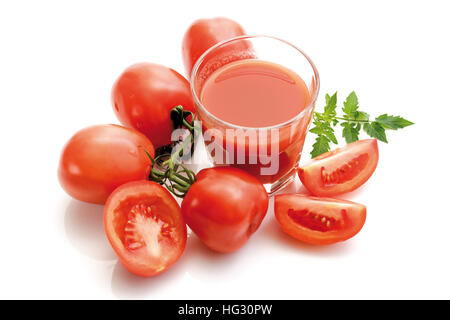 Bicchiere di succo di pomodoro circondato da i pomodorini, antiche varietà di pomodoro (Lycopersicon esculentum) Foto Stock