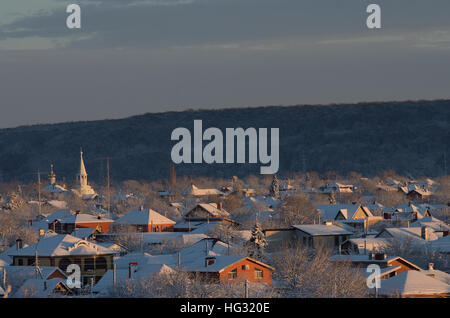 Tserkov ortodossa tra case a un piano. Sera d'inverno. Dopo la caduta di neve. Bella luce. Caucaso, Russia, Adygea. Foto Stock