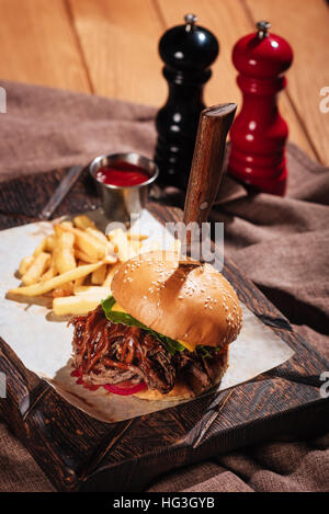 Gustosa burger essendo servito con patate fritte Foto Stock