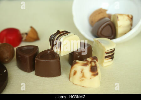 Varie praline di cioccolato su sfondo bianco Foto Stock