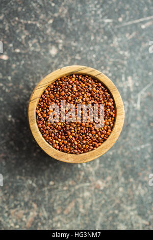 Quinoa rosso semi nella ciotola di legno. Foto Stock