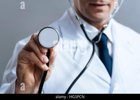 Chiudere smart medico tenendo uno stetoscopio Foto Stock