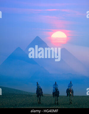 La luna piena sorge dietro le piramidi al tramonto, Giza, il Cairo, Egitto Foto Stock