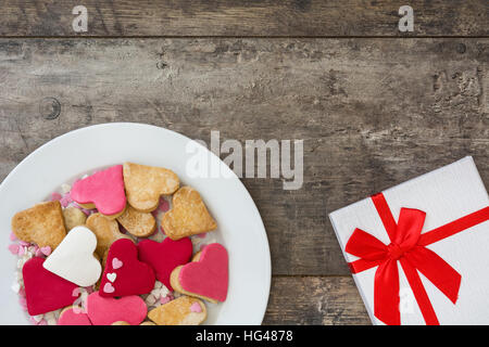 Valentine cookies a forma di cuore in piastra su sfondo di legno Foto Stock