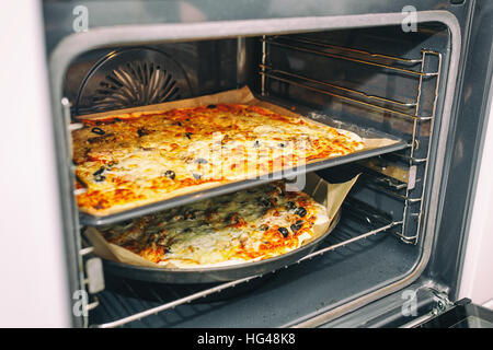 Pizze in uscita dal forno. Cibo sano concetto. Messa a fuoco selettiva. Foto Stock