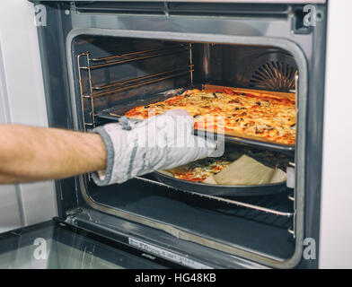 Pizze in uscita dal forno. Cibo sano concetto. Messa a fuoco selettiva. Foto Stock