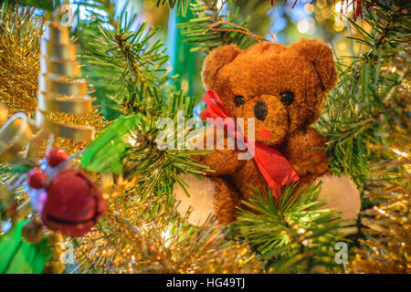 Orsacchiotto di peluche ornamento in un albero di Natale con una profondità di campo ridotta. Foto Stock
