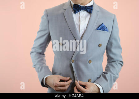 Uomo in abito grigio, plaid texture, blue bowtie e pocket Square, vicino su sfondo bianco Foto Stock