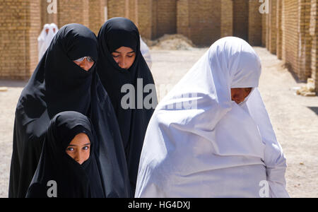 Diverse generazioni differenti visioni, nonna in bianco chador e donne in nero lo chador, Varzaneh, Iran Foto Stock