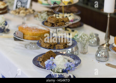 Il tè del pomeriggio wedding diffusione impostato su blu e bianca porcellana compresi tiered stand, candeliere e fiori Foto Stock