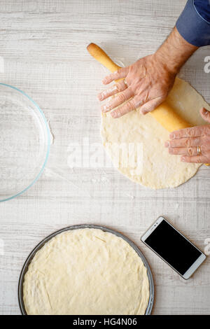 L'uomo la cottura di pasta per due pizze sulla verticale di cucina Foto Stock