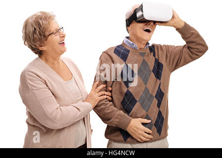 Allegro uomo maturo utilizzando un auricolare VR con una donna matura la mano isolati su sfondo bianco Foto Stock