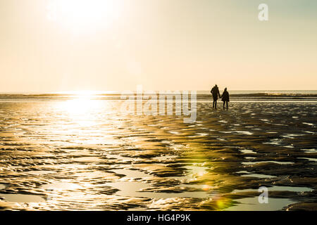 Un paio di camminare sulla spiaggia la sera Foto Stock