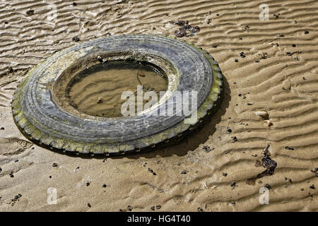 Pneumatico vecchio scartato sulla spiaggia Foto Stock