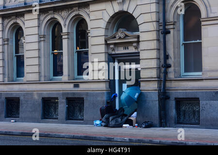 La persona senza dimora dormire in una porta di un edificio nella zona di Deansgate, Manchester City Centre. Foto Stock