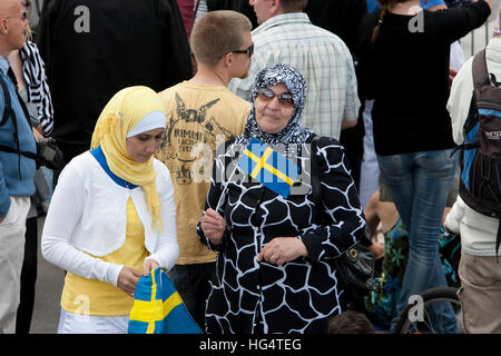Le donne immigrate con bandiera svedese. Foto Stock