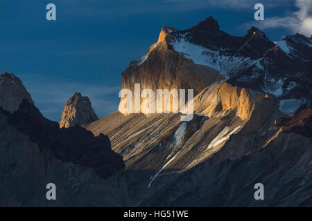 Tramonto spettacolare la luce illumina il giallo faccia di granito del Monte Almirante Nieto. Una nube getta un ombra, creando una banda oscura attraverso la faccia. A Foto Stock