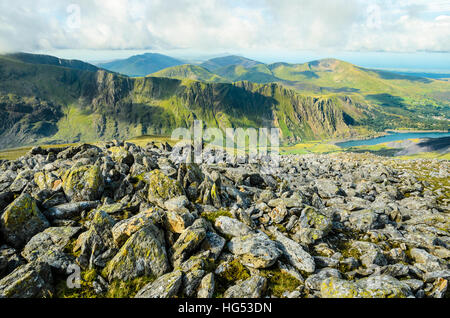 Terra rocciosa vicino al vertice di Y Garn Snowdonia Galles del Nord guardando sopra Llyn Peris a Eilio Moel e le lontane Nantlle Ridge Foto Stock