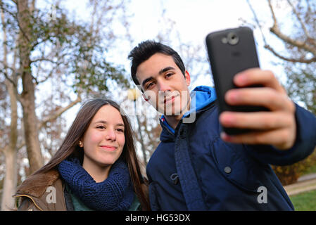 Gli adolescenti prendendo un selfie in posizione di parcheggio Foto Stock